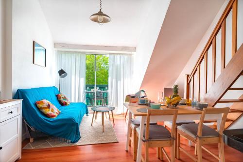 拉福雷富埃南Bananec- Appt à 300 mètres de la plage的客厅配有蓝色的沙发和桌子