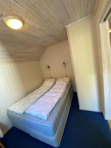 克拉格勒Bergland apartment 28 - close to the center of Kragerø的小型客房的一张床位,设有天花板