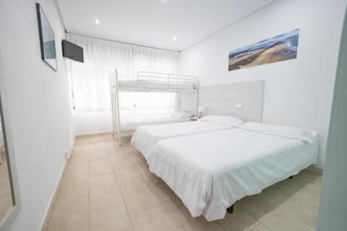 擞莫擞莫皮纳尔冲浪酒店的一间白色卧室,配有两张床和窗户