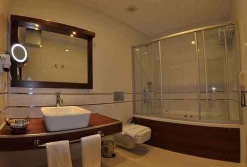 图尔古特雷斯Small Beach Hotel的带淋浴、盥洗盆和浴缸的浴室