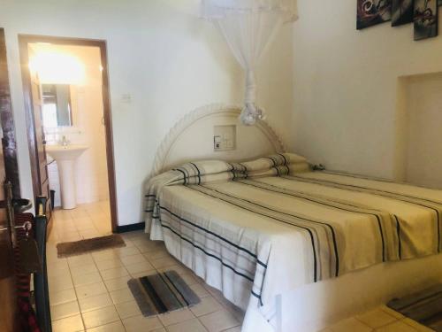 本托塔荷马旦酒店的卧室配有一张床,位于带水槽的房间