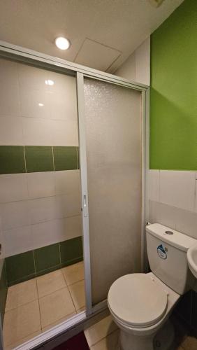 Marikina20 Studio Hotel的一间带卫生间和推拉式淋浴门的浴室