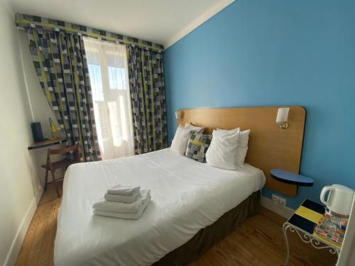 勒阿弗尔Oscar Hôtel Le Havre Centre的一间卧室配有带毛巾的床
