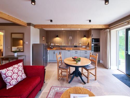 赛伦塞斯特Luxury Lodge @ Ewen Barn - private 5* retreat的客厅配有红色的沙发和桌子