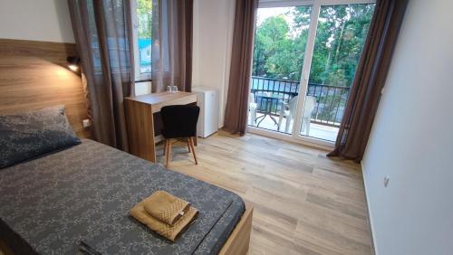 奥赫里德Villa Natali的一间卧室设有一张床,享有阳台的景色