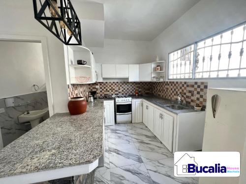马查拉Bucalia House Machala的厨房配有白色橱柜和大理石台面