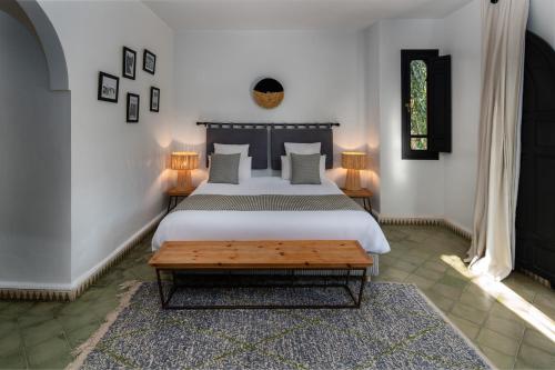 马拉喀什Villa Al Assala Palmeraie的一间卧室配有一张大床和一张桌子