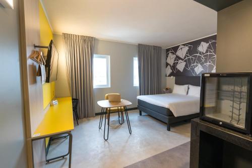 安托法加斯塔ibis Styles Antofagasta的一间酒店客房,配有一张床铺、一张桌子和一台电视
