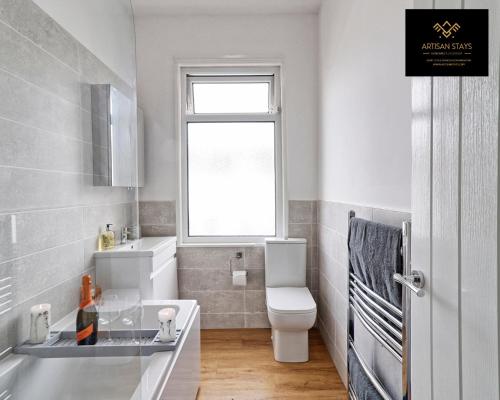滨海绍森德Deluxe Apartment in Southend-On-Sea by Artisan Stays I Free Parking I Perfect for Contractors or Families的一间带水槽和卫生间的浴室以及窗户。