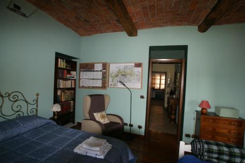 阿维利亚纳Antiche Mura的一间卧室配有一张床、一把椅子和一个书架