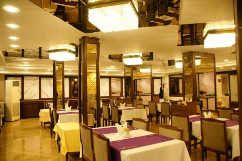安卡拉阿尔芬酒店的餐厅配有白色的桌椅和灯光
