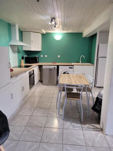 卡尔卡松CINSAULT的厨房配有桌子和绿色的墙壁