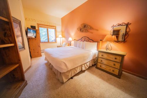 基斯通Arapahoe Lodge 8105的一间卧室配有一张大床和一个木制梳妆台