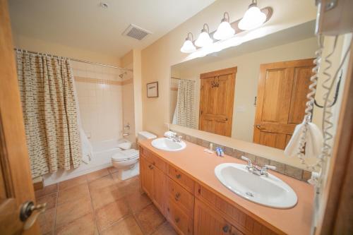 基斯通Springs 8909的浴室设有2个水槽、卫生间和镜子。