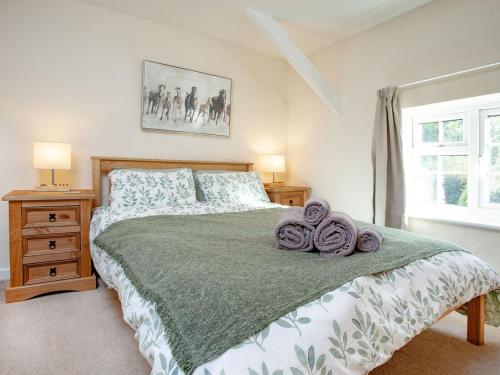 奥特里圣玛丽Otters Cottage的一间卧室配有一张大床和毛巾