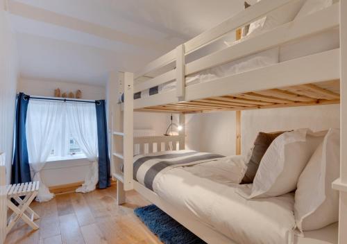 雷文斯卡2 Browcote Cottage的一间卧室配有两张双层床和一张书桌