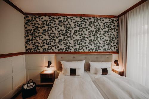 黑灵斯多夫Villa Usedom的卧室配有白色床和黑白壁纸