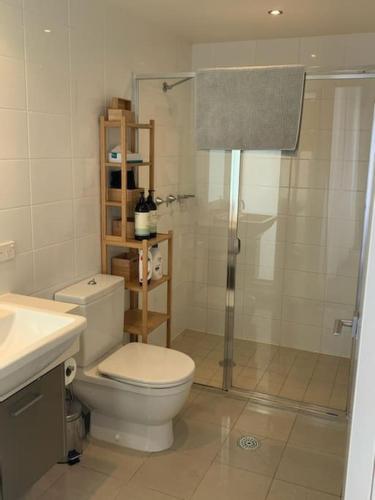 堪培拉Spacious sun-drenched apartment, centrally located的浴室配有卫生间、淋浴和盥洗盆。