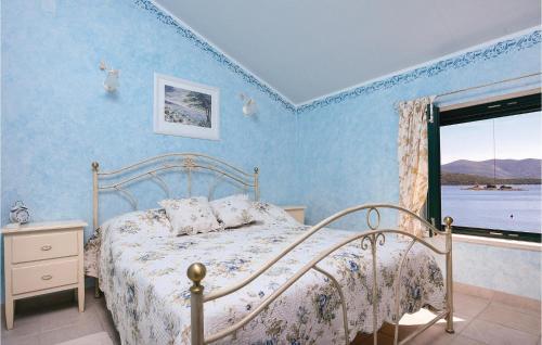 克勒克Stunning Home In Klek With Wifi的一间卧室配有一张蓝色墙壁的床和一扇窗户