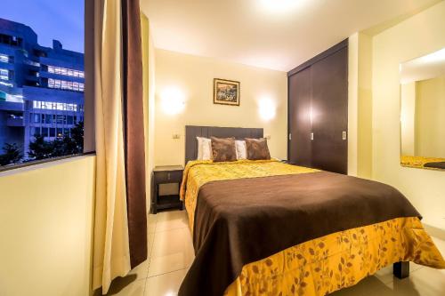 利马范宁酒店的一间卧室设有一张床和一个大窗户