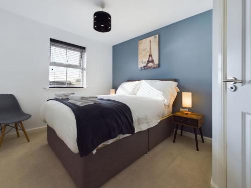 斯塔福德247 Serviced Accommodation in Stafford- 3BR Townhouse的一间卧室设有一张蓝色墙壁的大床