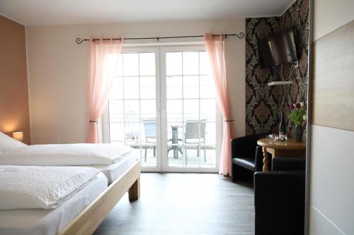 特赖斯-卡尔登科奈普旅馆的一间卧室配有一张床,窗户配有桌子