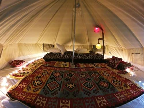 费特希耶Butterfly Valley Beach Glamping的帐篷内的一张床位,上面有毯子