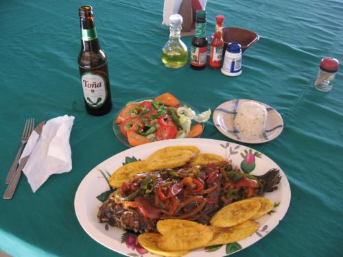 DiriambaFinca Joco Mico的一张桌子,上面放着一盘食物和一瓶啤酒