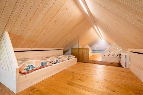 MalenoviceApartmány U 3 Zbujů的客房位于带木制天花板的阁楼,配有一张床。