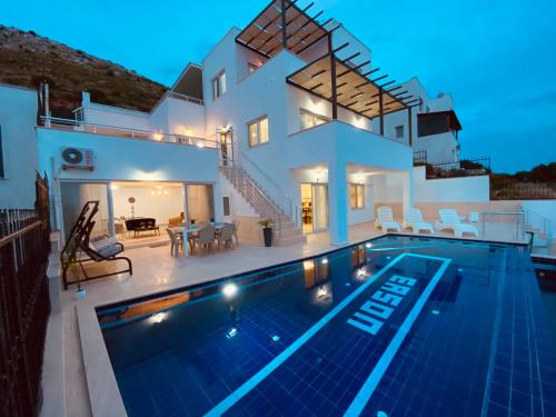 博德鲁姆Bodrum eaSon Villa & House 350m2 Full Sea View with Private Infinity Pool的别墅前设有游泳池