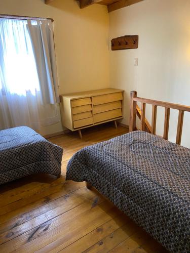 埃斯克尔艾林公寓的一间卧室设有两张床、一个梳妆台和窗户。