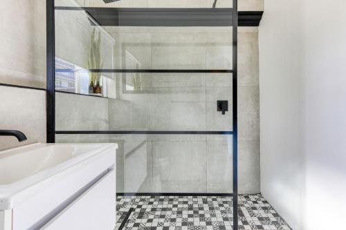 开普敦Backup-Power Trendy 2 Bed Balcony Apartment的一个带水槽的浴室内的玻璃淋浴间门