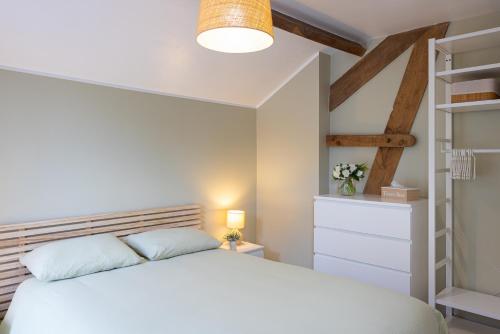 讷沙托Gîte Le Haut des Vannes的卧室配有白色的床和书架