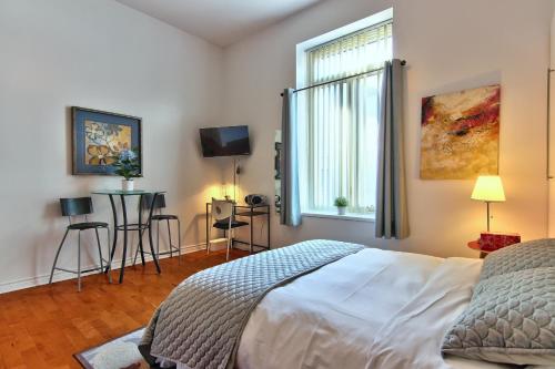 蒙特利尔Apartment et Studio montreal的一间卧室设有一张床、一个窗口和一台电视
