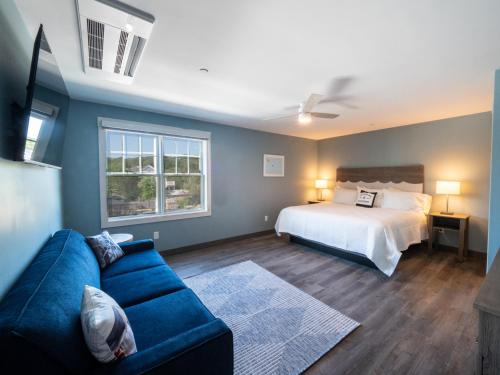格洛斯特Long Beach Suites的客厅配有床和蓝色沙发