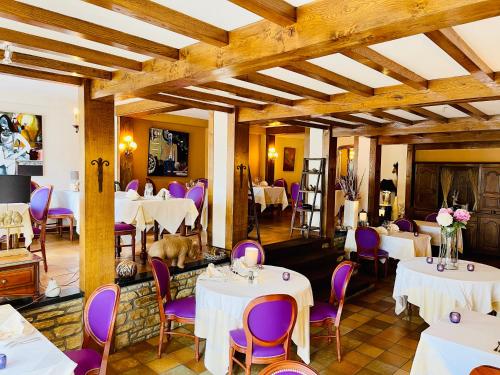 弗洛朗维尔Hostellerie Sainte-Cécile的餐厅配有白色桌子和紫色椅子