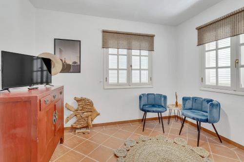 克拉伦代克Villa Aventura的客厅配有2把蓝色椅子和电视