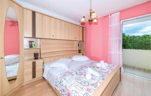 Primorski Dolac4 Bedroom Stunning Home In Primorski Dolac的一间卧室配有一张粉红色墙壁的床
