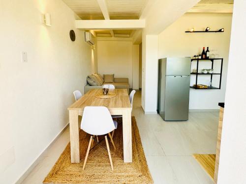 锡拉库扎Plemmirio Apartment的厨房配有木桌和冰箱。