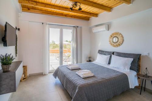 苏卡雷斯Elianthos Luxury Villas的一间卧室设有一张床和一个大窗户