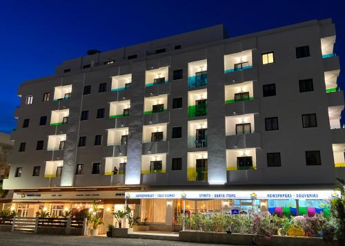 圣安东尼奥Aparthotel Boutique Poniente Playa的夜间酒店外貌的 ⁇ 染