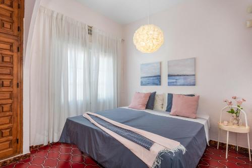 托雷维耶哈Beautiful house with sea views and private pool的一间卧室配有一张带蓝色床单和粉红色枕头的床。
