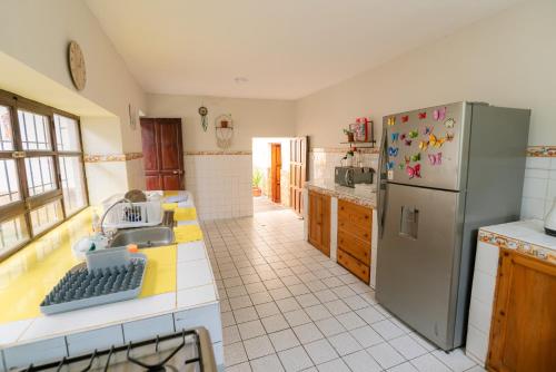 Los Baños del IncaKinti Wasi Casa de Campo的厨房配有不锈钢冰箱和瓷砖地板。