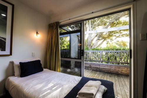 怀希比奇Tasman Holiday Parks - Waihi Beach的一间卧室设有一张床和一个大窗户