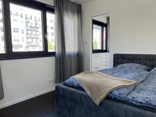 柏林Luxury Waterfront Apartment的一间卧室设有一张床和两个窗户。