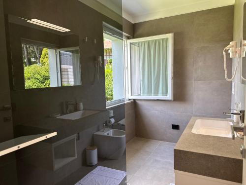 Magnano in RivieraHotel Riviera的一间带水槽和卫生间的浴室以及窗户。