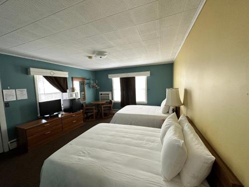 沃特金斯格伦The Colonial Inn & Creamery的酒店客房设有两张床和电视。