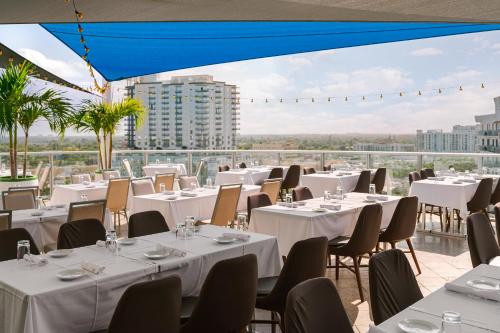 好莱坞The Circ powered by Sonder的一间设有白色桌椅的餐厅,享有美景。