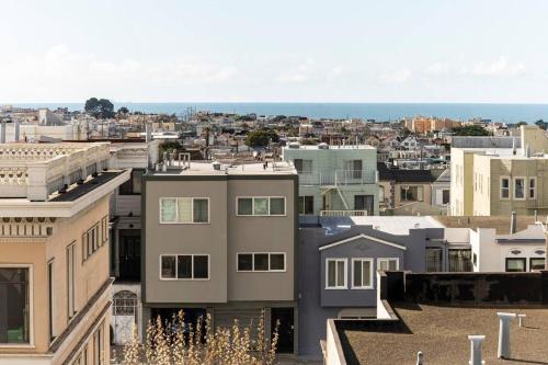 旧金山Sunset Edwardian Bed and Breakfast At Golden Gate Park San Francisco的享有拥有建筑和大海的城市美景