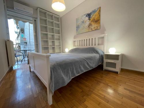 雅典Traveller's Choice Attiki的卧室配有一张床和两盏灯,铺有木地板。